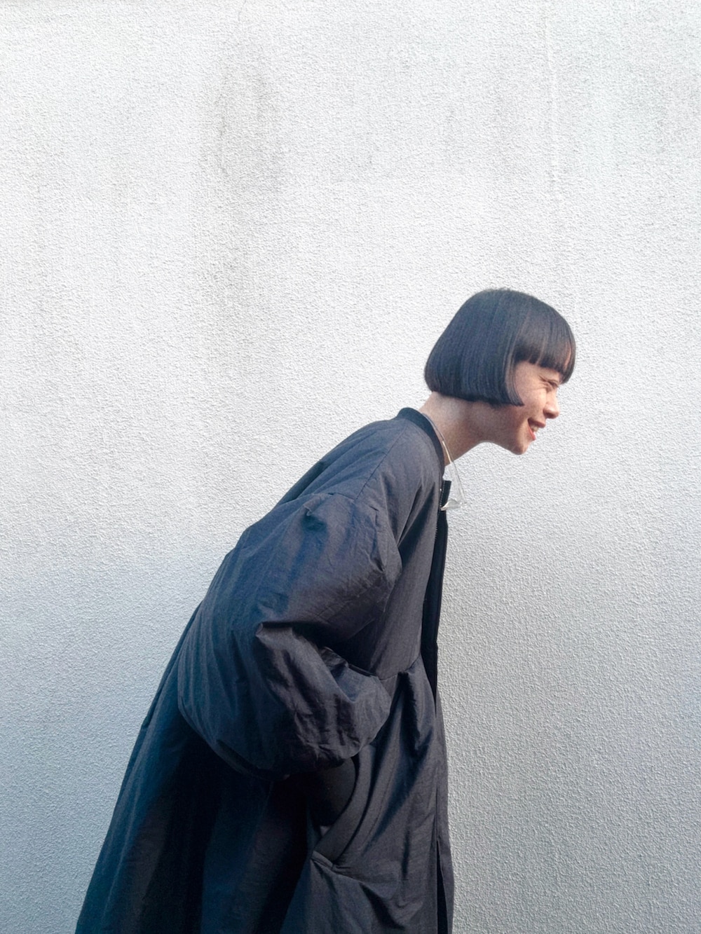 ブラック系のシューズ、ブルー系のデニムパンツ、ブラック系のダウンジャケット/コートを着用したレディースの春コーディネートの3枚目の写真