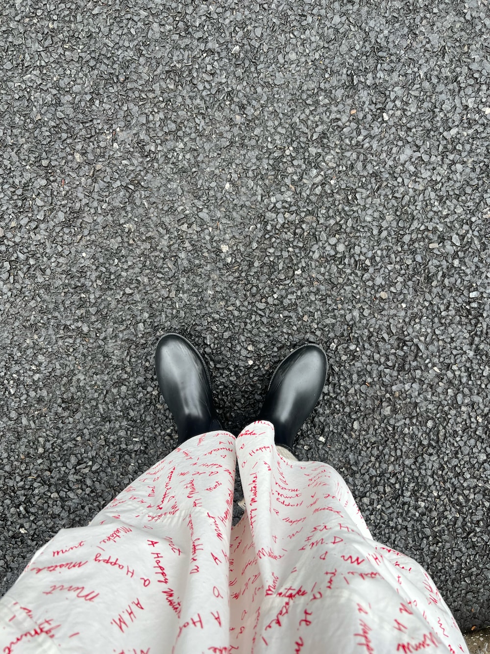 ホワイト系のスカート、ブラック系のバッグ、ブラック系のブーツを着用したレディースの春コーディネートの3枚目の写真