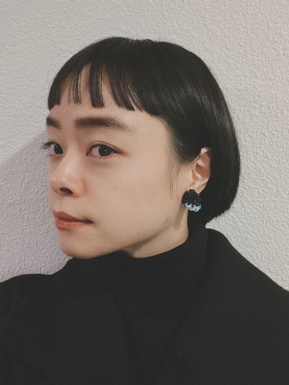 ブラック系のピーコート、ブラック系のトートバッグ、ベージュ系のスカートを着用したレディースの冬コーディネートの2枚目の写真