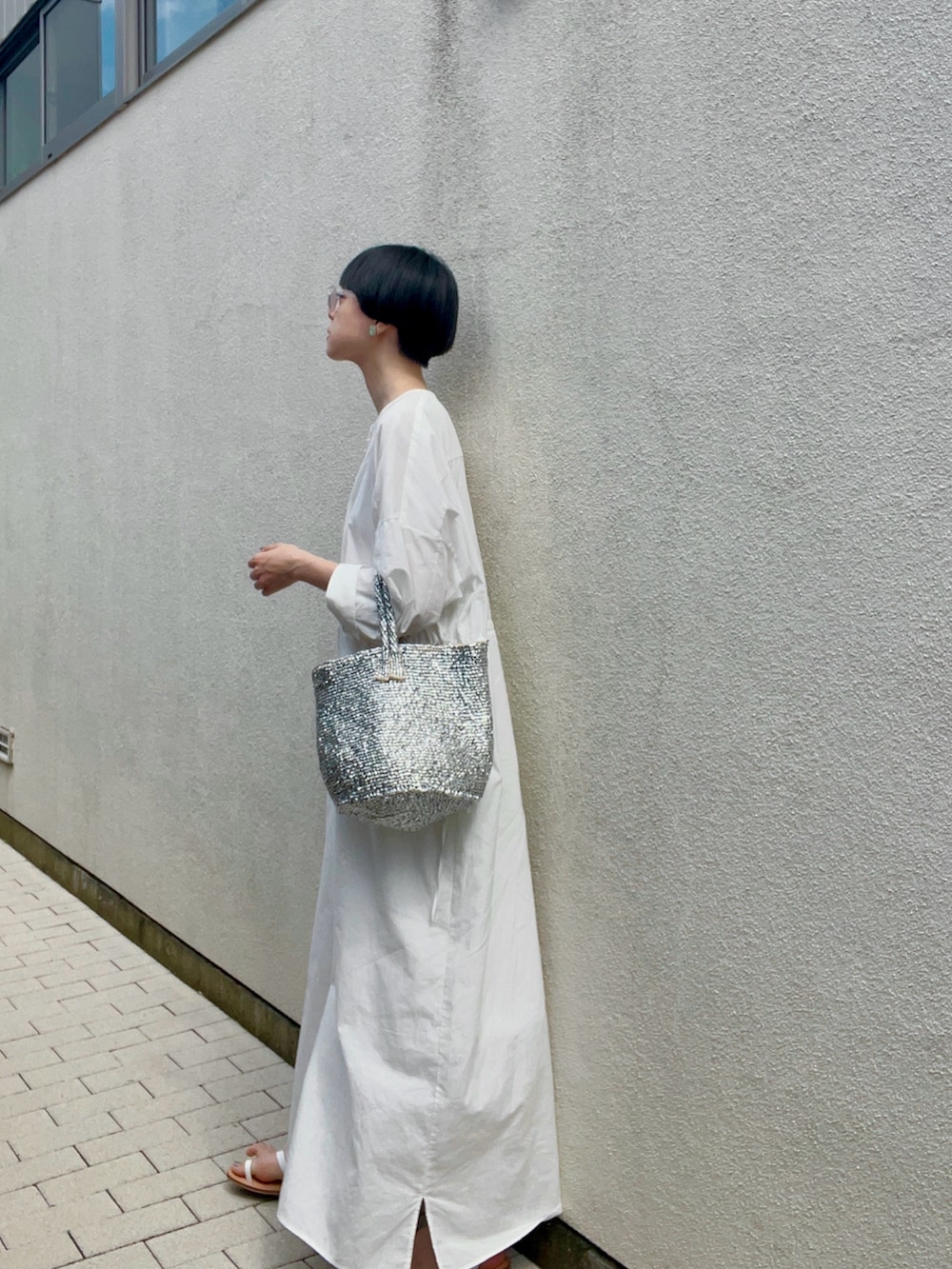 シルバー系のバッグ、ホワイト系のサンダル、ホワイト系のワンピース/ドレスを着用したレディースの夏コーディネートの2枚目の写真