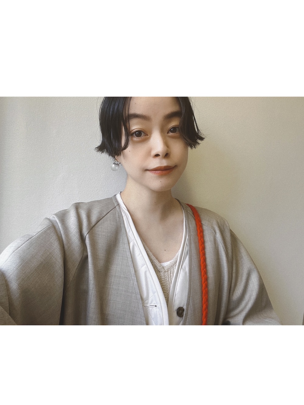 レッド系のバッグ、ベージュ系のジャケット/アウター、ベージュ系のワンピースを着用したレディースの秋コーディネートの3枚目の写真