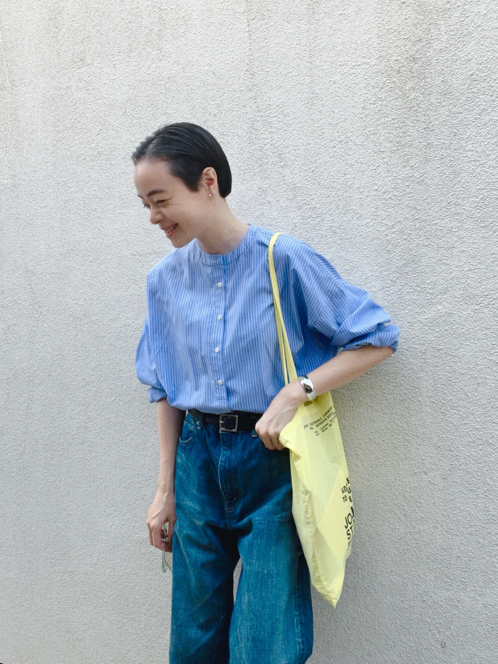 ブルー系のシャツ/ブラウス、イエロー系のトートバッグ、ブルー系のデニムパンツを着用したレディースの秋コーディネートの2枚目の写真