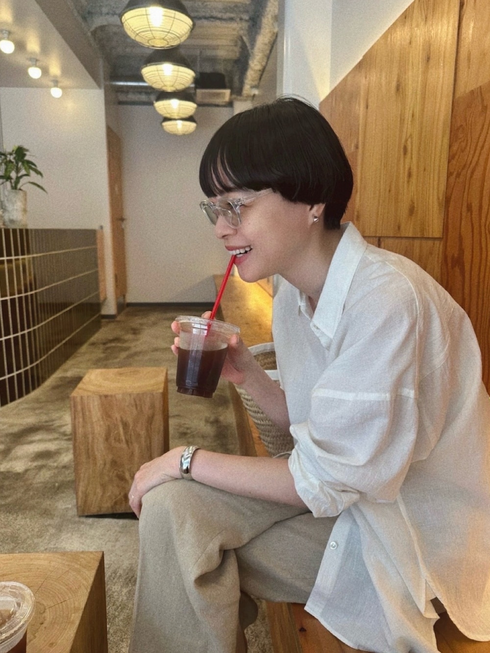 ホワイト系のかごバッグ、ホワイト系のシャツ/ブラウス、ベージュ系のパンツを着用したレディースの夏コーディネートの2枚目の写真