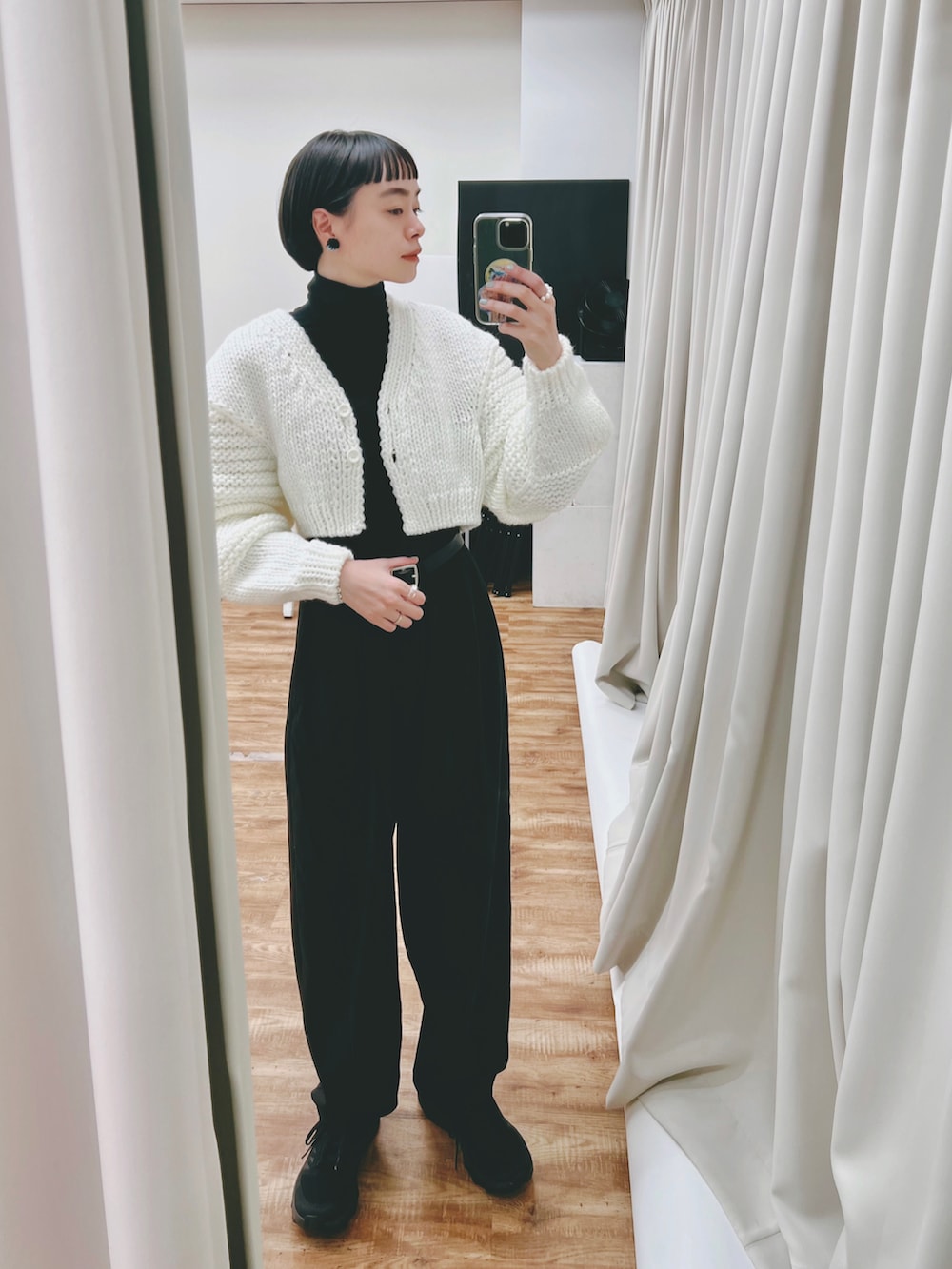 ホワイト系のカーディガン/ボレロ、ブラック系のTシャツ/カットソー、ブラック系のスラックスを着用したレディースの冬コーディネートの2枚目の写真