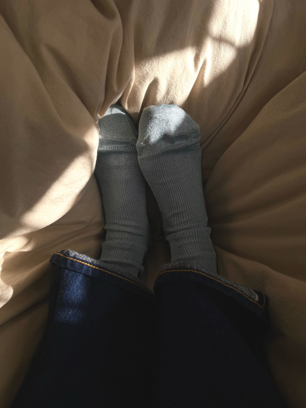 ブルー系のデニムパンツ、ブラック系のカーディガン/ボレロ、グレー系のTシャツ/カットソーを着用したレディースの冬コーディネートの5枚目の写真