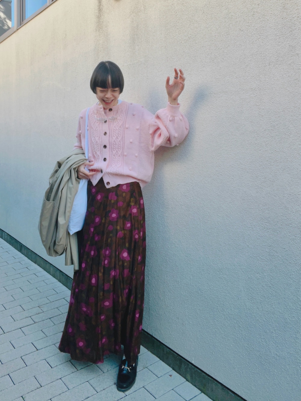 ブラウン系のスカート、ピンク系のカーディガン/ボレロ、ホワイト系のTシャツ/カットソーを着用したレディースの秋コーディネートの2枚目の写真