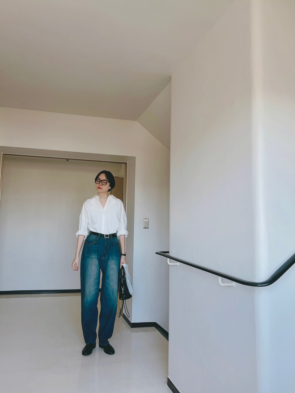 ホワイト系のシャツ/ブラウス、ブルー系のデニムパンツ、ブラック系のシューズを着用したレディースの秋コーディネートの2枚目の写真