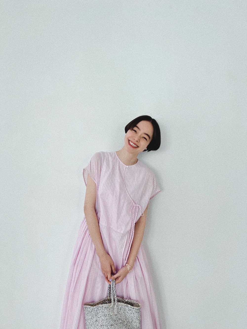 ピンク系のワンピースを着用したレディースの春コーディネートの3枚目の写真