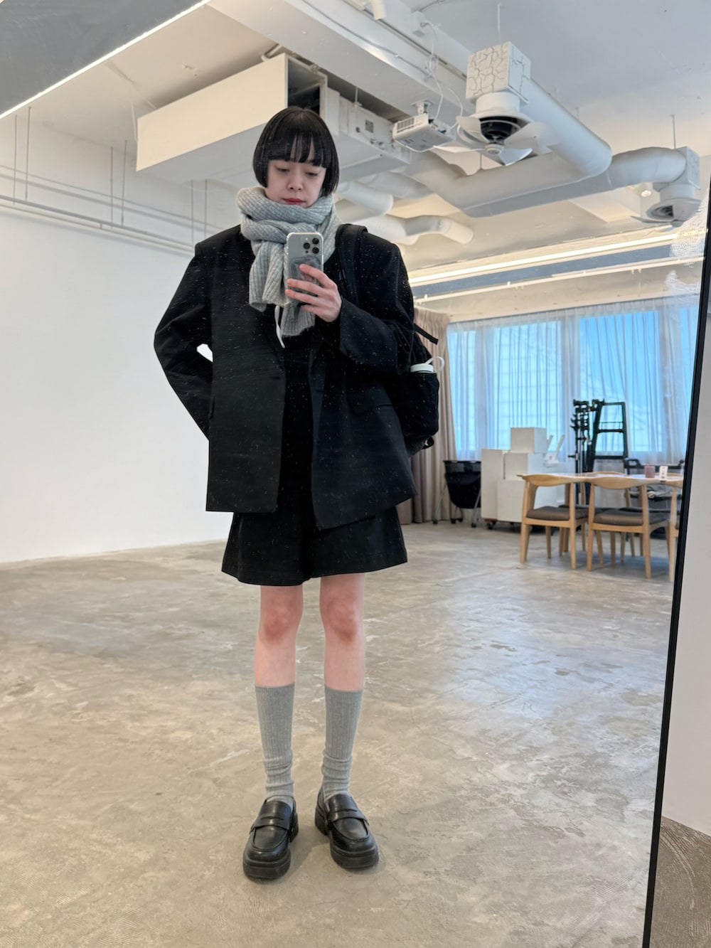 ブラック系のパンプス、ブラック系のテーラードジャケット、ブラック系のバックパック/リュックを着用したレディースの冬コーディネートの3枚目の写真