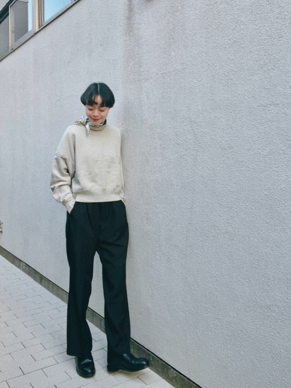 ブラック系のスラックス、ベージュ系のスウェット、ブラック系のドレスシューズを着用したレディースの冬コーディネートの2枚目の写真