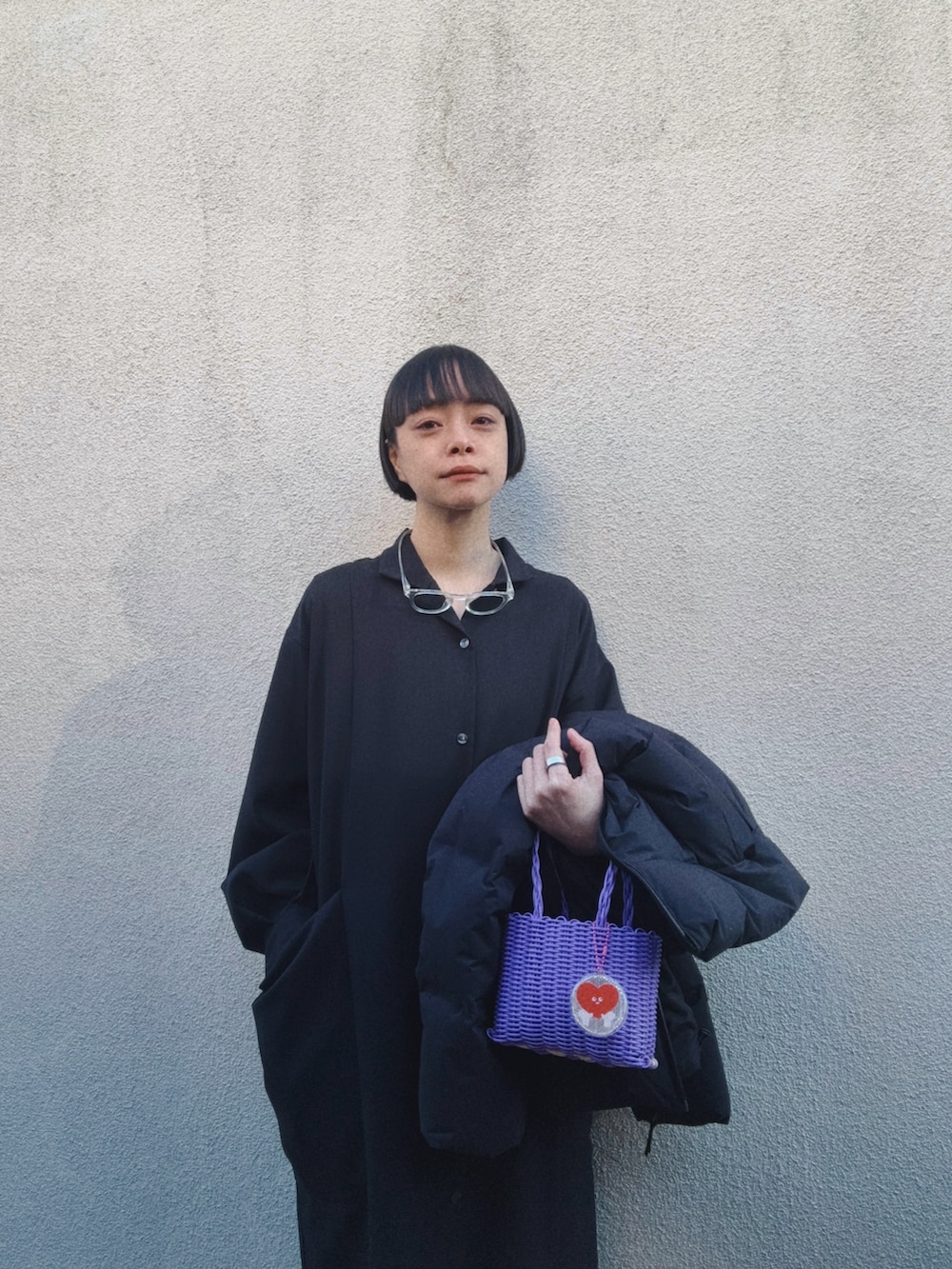 ブラック系のドレス、パープル系のバッグ、ブラック系のダウンジャケット/コートを着用したレディースの冬コーディネートの4枚目の写真