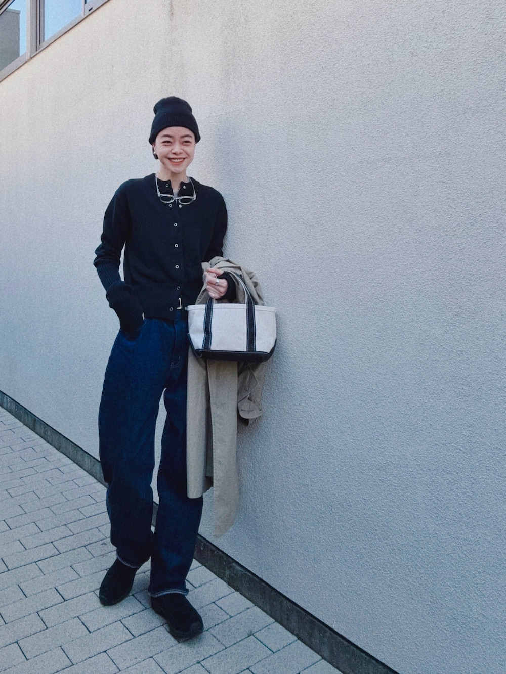 ブルー系のデニムパンツ、ブラック系のカーディガン/ボレロ、グレー系のTシャツ/カットソーを着用したレディースの冬コーディネートの2枚目の写真