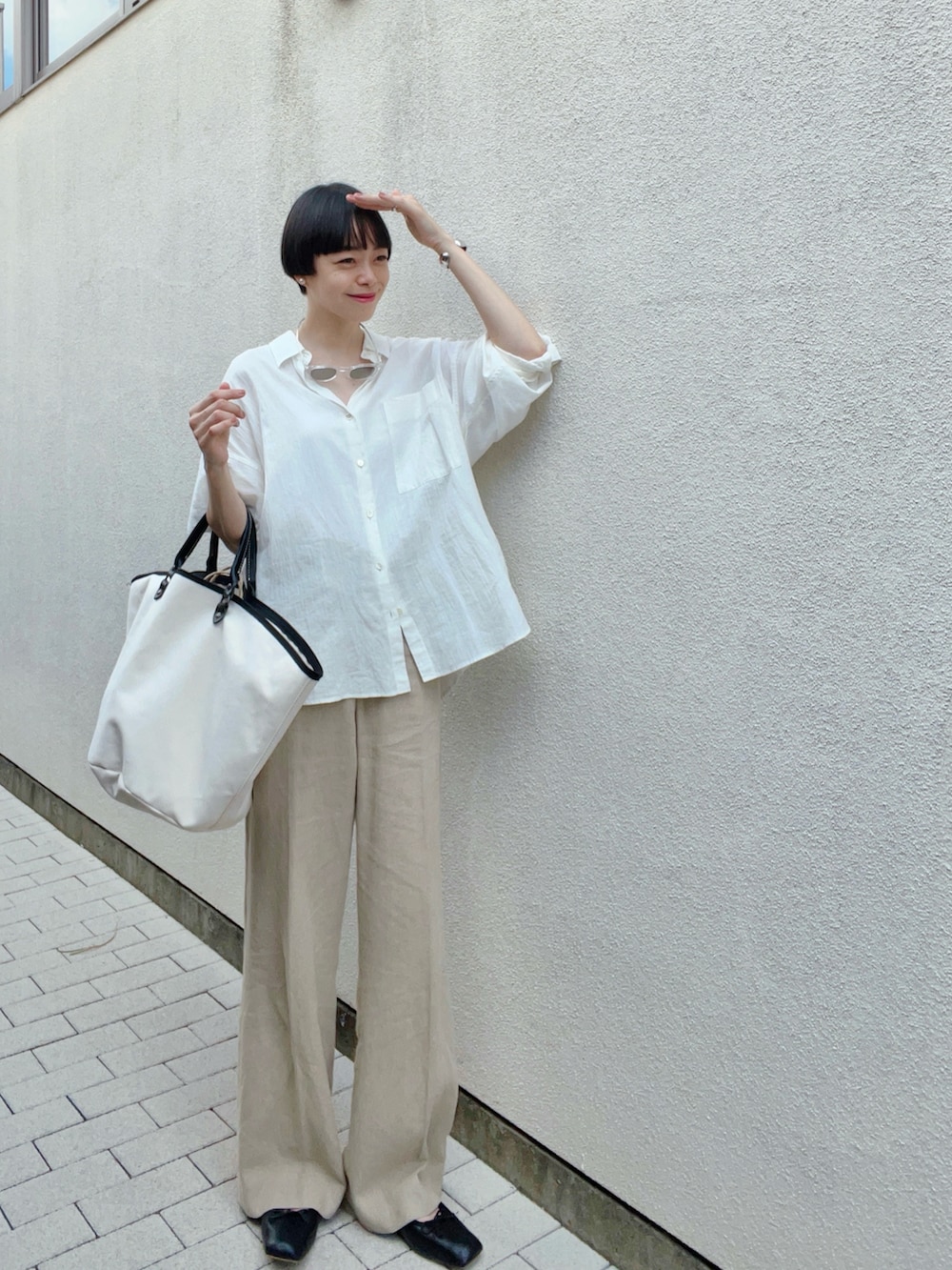 ホワイト系のシャツ/ブラウス、ベージュ系のパンツ、ホワイト系のバッグを着用したレディースの秋コーディネートの2枚目の写真