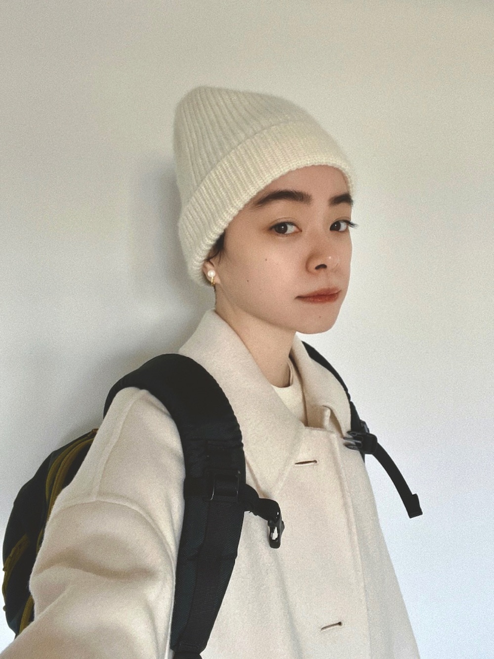 ホワイト系のニット/セーター、ホワイト系のサロペット/オーバーオール、ホワイト系のその他アウターを着用したレディースの冬コーディネートの2枚目の写真