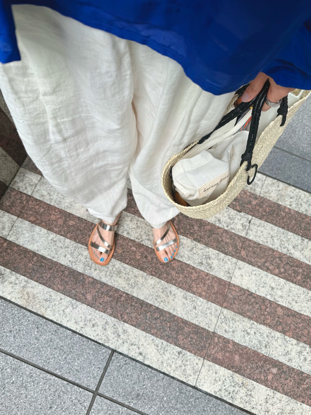 ブルー系のシャツ/ブラウス、ホワイト系のパンツ、ベージュ系のかごバッグを着用したレディースの夏コーディネートの4枚目の写真