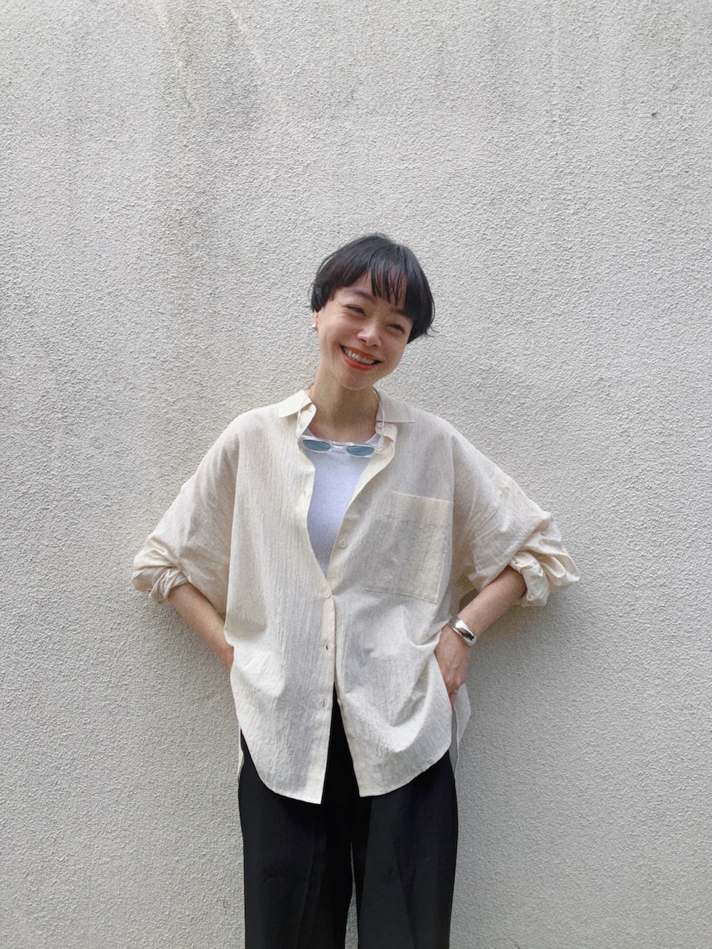 ベージュ系のシャツ/ブラウス、ホワイト系のタンクトップ、ブラック系のスラックスを着用したレディースの夏コーディネートの3枚目の写真