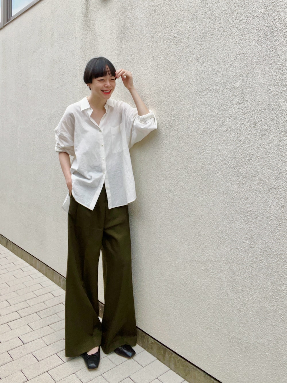 ホワイト系のシャツ/ブラウス、グリーン系のスラックス、ブラック系のバレエシューズを着用したレディースの秋コーディネートの2枚目の写真