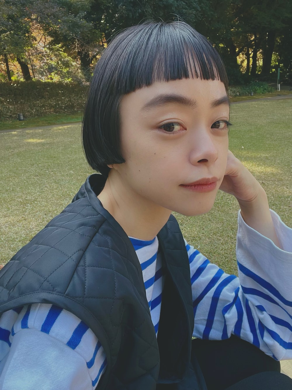 ブルー系のトップス、ブラック系のベスト、ブラック系のパンツを着用したレディースの秋コーディネートの2枚目の写真