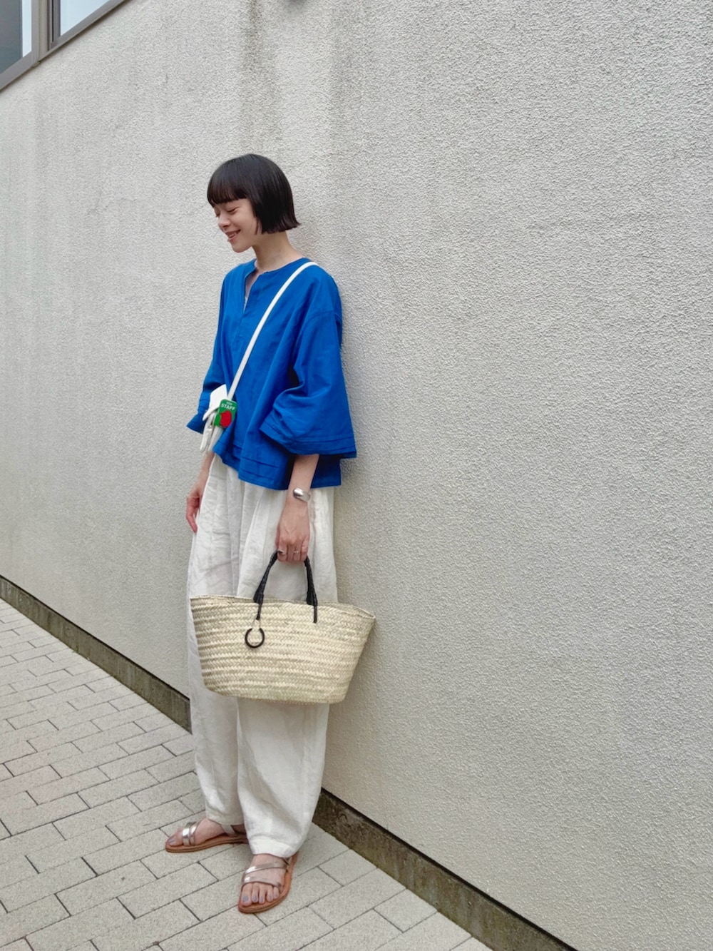 ブルー系のシャツ/ブラウス、ホワイト系のパンツ、ベージュ系のかごバッグを着用したレディースの夏コーディネートの2枚目の写真