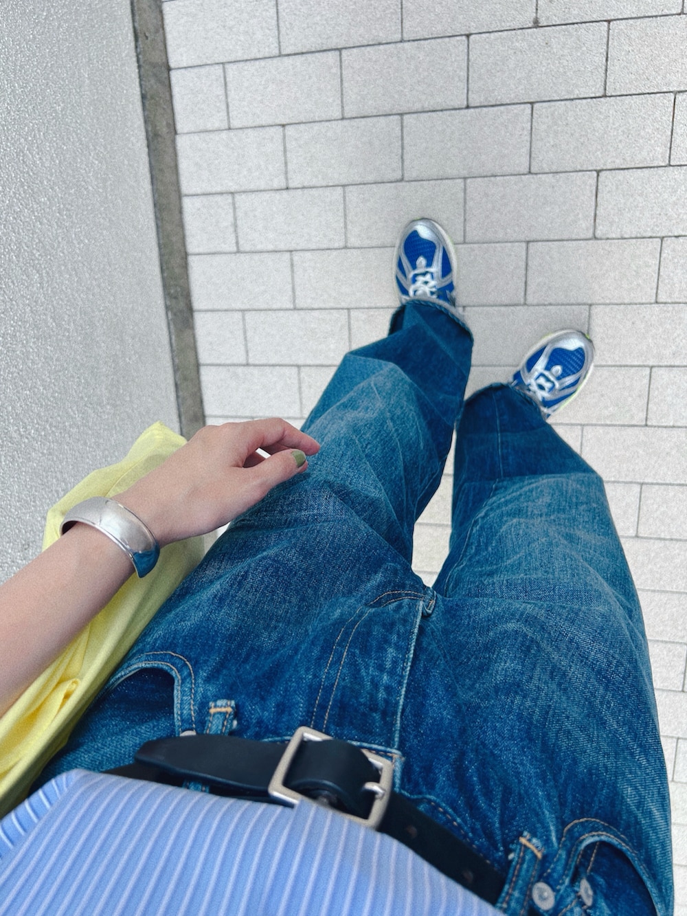 ブルー系のシャツ/ブラウス、イエロー系のトートバッグ、ブルー系のデニムパンツを着用したレディースの秋コーディネートの3枚目の写真