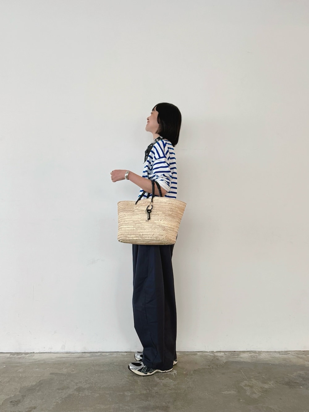 ブルー系のその他パンツ、ブルー系のTシャツ/カットソー、ベージュ系のかごバッグを着用したレディースの秋コーディネートの3枚目の写真
