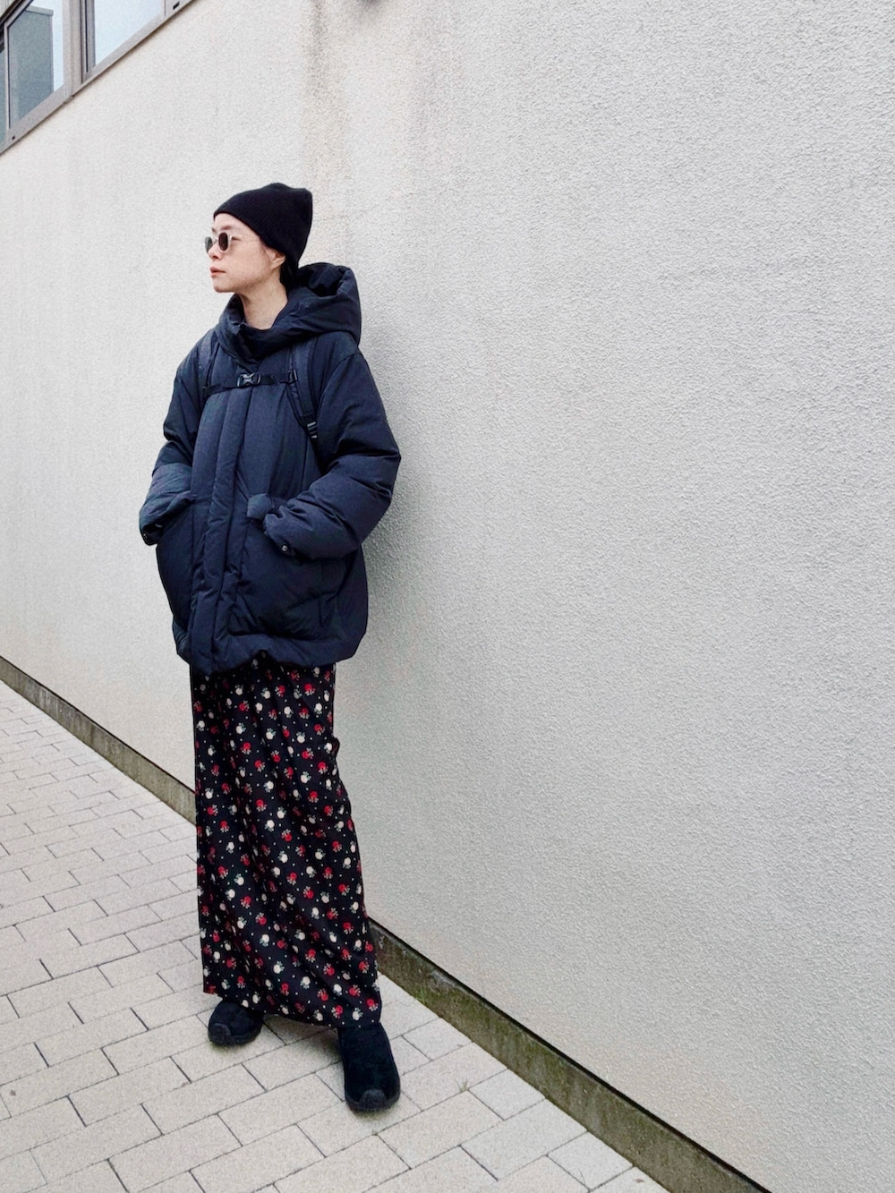 ブラック系のスカート、ブルー系のスウェット、ブラック系のダウンジャケット/コートを着用したレディースの冬コーディネートの2枚目の写真