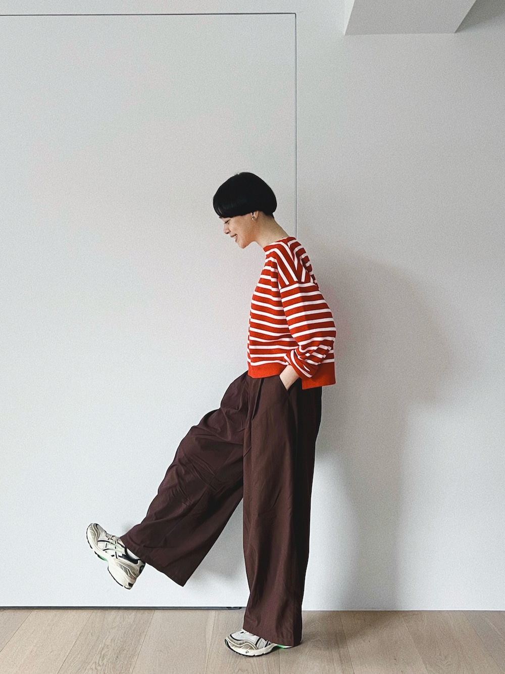 ブラウン系のその他パンツ、レッド系のトップス、ベージュ系のスニーカーを着用したレディースの秋コーディネートの3枚目の写真