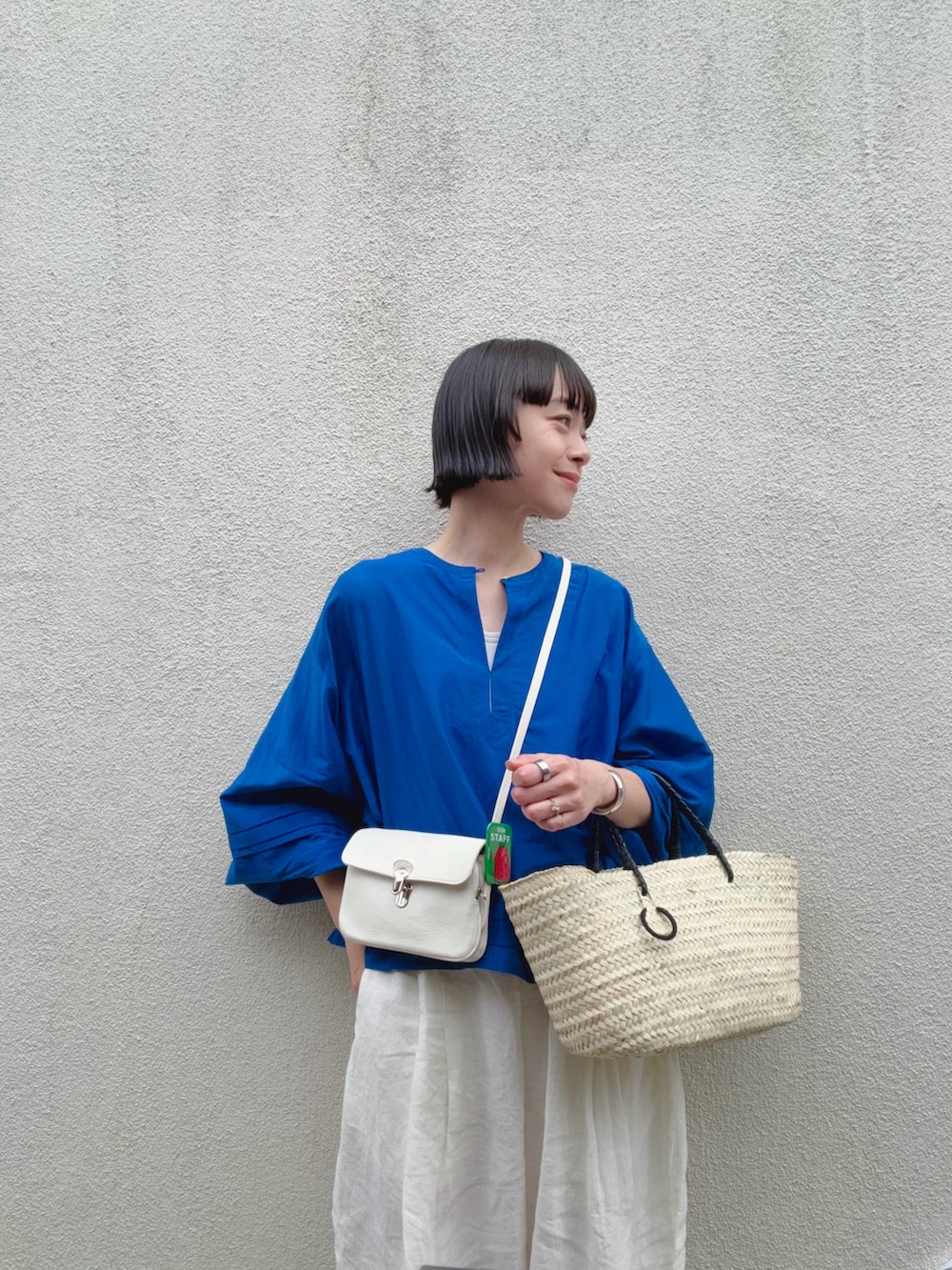ブルー系のシャツ/ブラウス、ホワイト系のパンツ、ベージュ系のかごバッグを着用したレディースの夏コーディネートの3枚目の写真