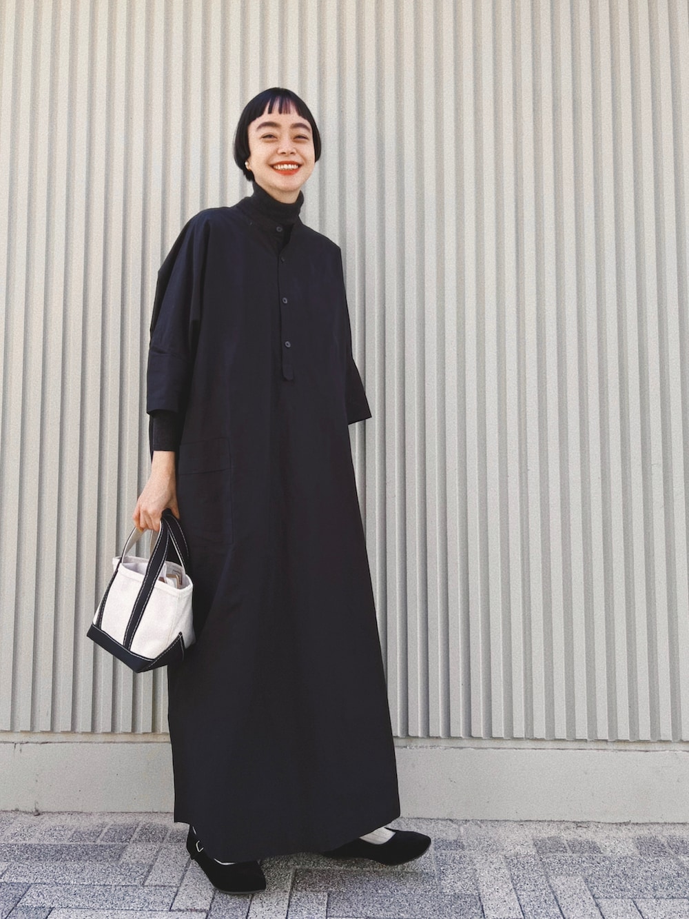 ブラック系のワンピース/ドレス、ブラック系のトートバッグ、ブラック系のバレエシューズを着用したレディースの冬コーディネートの2枚目の写真