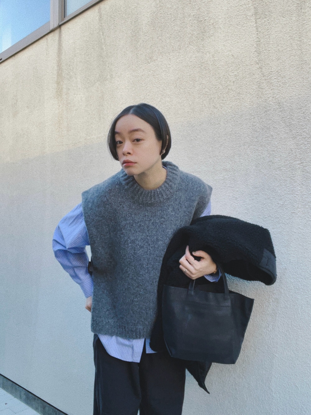 ブルー系のシャツ/ブラウス、グレー系のベスト、ブラック系のパンツを着用したレディースの冬コーディネートの2枚目の写真