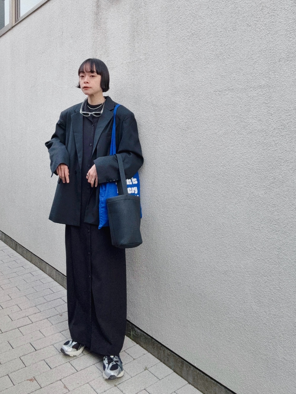 ブラック系のスニーカー、ブラック系のドレス、ブラック系のテーラードジャケットを着用したレディースの冬コーディネートの2枚目の写真