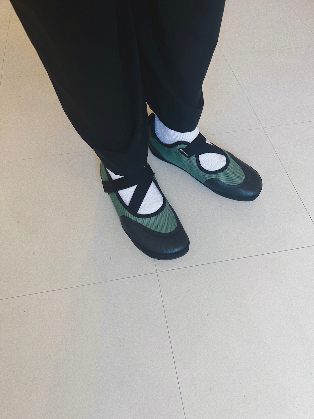 ブラック系のつなぎ/オールインワン、グリーン系のバレエシューズ、ブラック系の帽子を着用したレディースの秋コーディネートの2枚目の写真