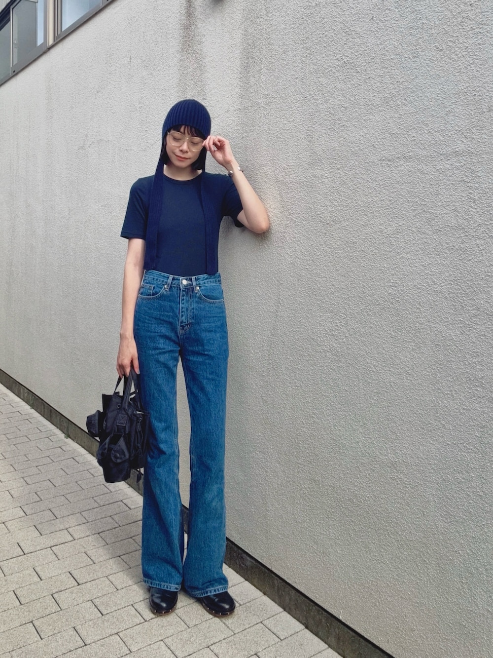 ブルー系のTシャツ/カットソー、ブラック系のバッグ、ブルー系のデニムパンツを着用したレディースの秋コーディネートの2枚目の写真