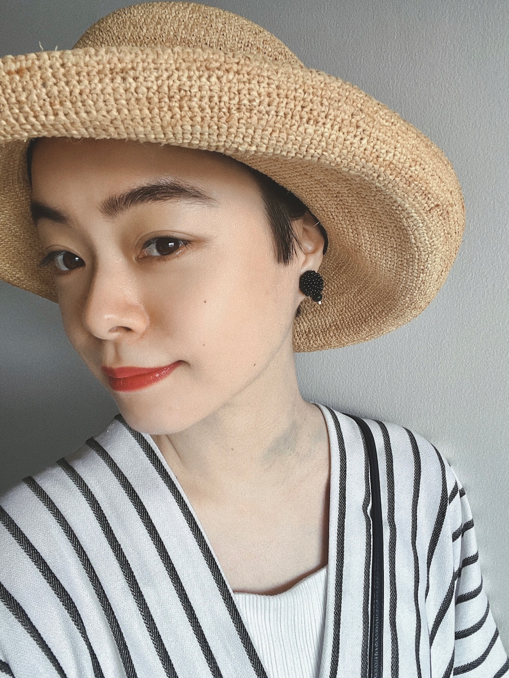 ホワイト系のワンピース、ブラック系のバッグ、ブラック系のサンダルを着用したレディースの夏コーディネートの2枚目の写真