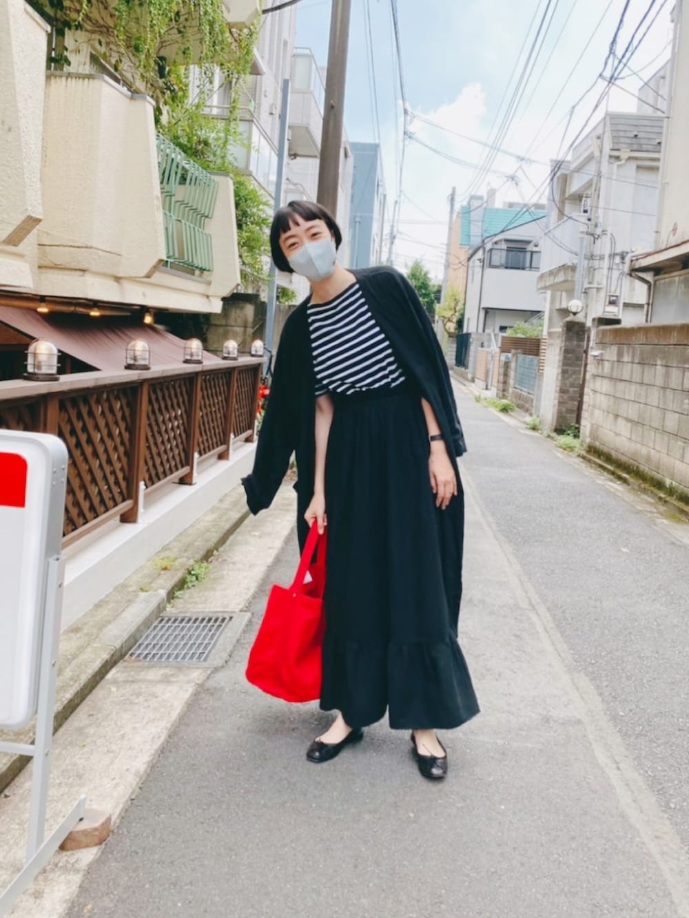 ブラック系のジャケット/アウター、ブラック系のスカート、レッド系のトートバッグを着用したレディースの秋コーディネートの2枚目の写真