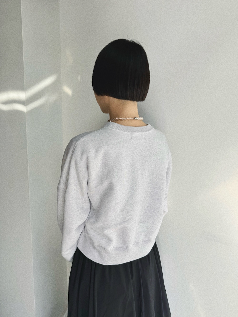 ブラック系のスカート、ブラック系のシューズ、ブラック系のダウンジャケット/コートを着用したレディースの冬コーディネートの2枚目の写真