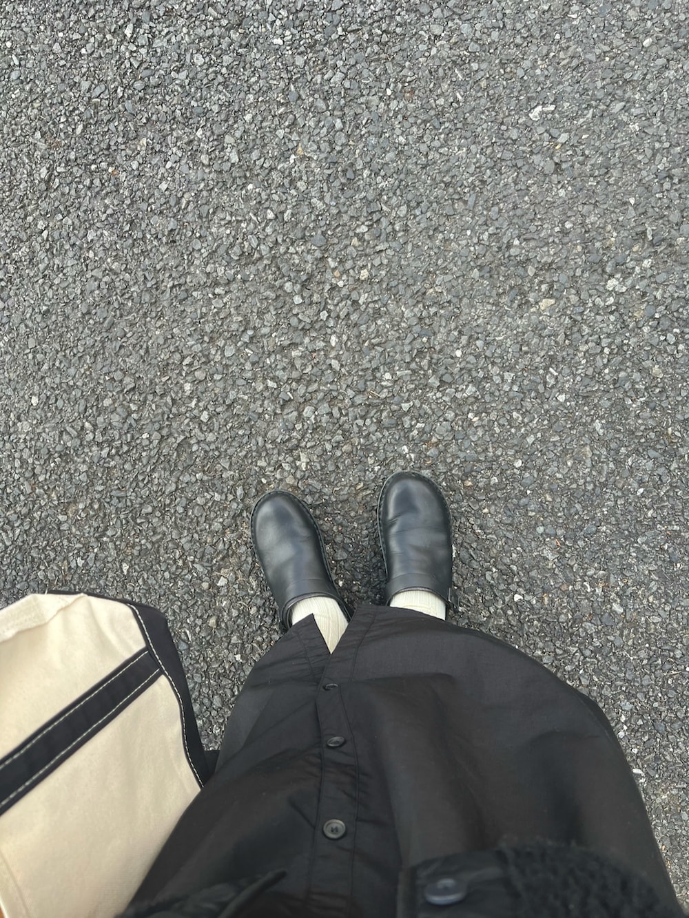 ブラック系のトートバッグ、ブラック系のノーカラージャケット、グレー系のベストを着用したレディースの冬コーディネートの3枚目の写真