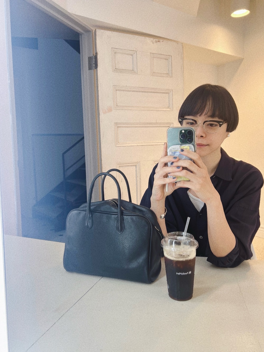 ブルー系のデニムパンツ、ブラック系のバレエシューズ、ブルー系のシャツ/ブラウスを着用したレディースの秋コーディネートの2枚目の写真