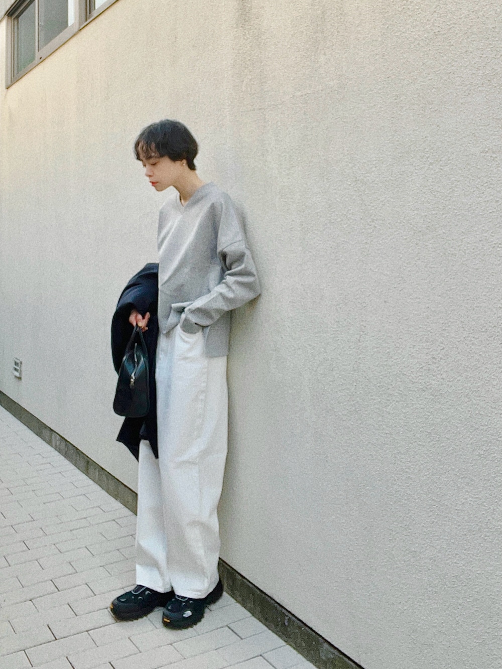 グレー系のスウェット、ホワイト系のデニムパンツ、ブラック系のシューズを着用したレディースの春コーディネートの2枚目の写真