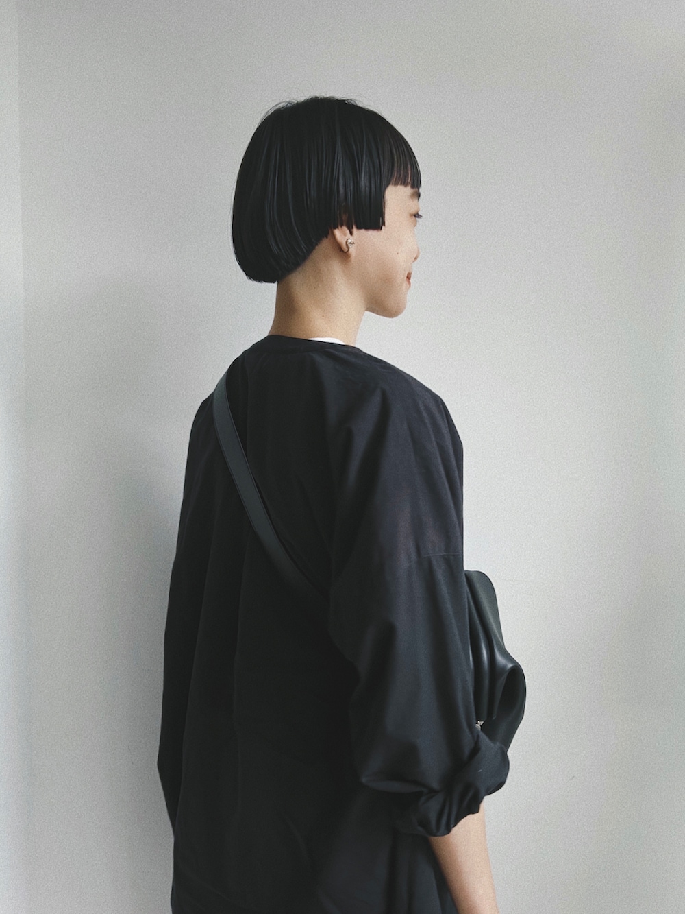 ブラック系のバッグ、ブラック系のシャツ/ブラウス、ホワイト系のTシャツ/カットソーを着用したレディースの春コーディネートの2枚目の写真