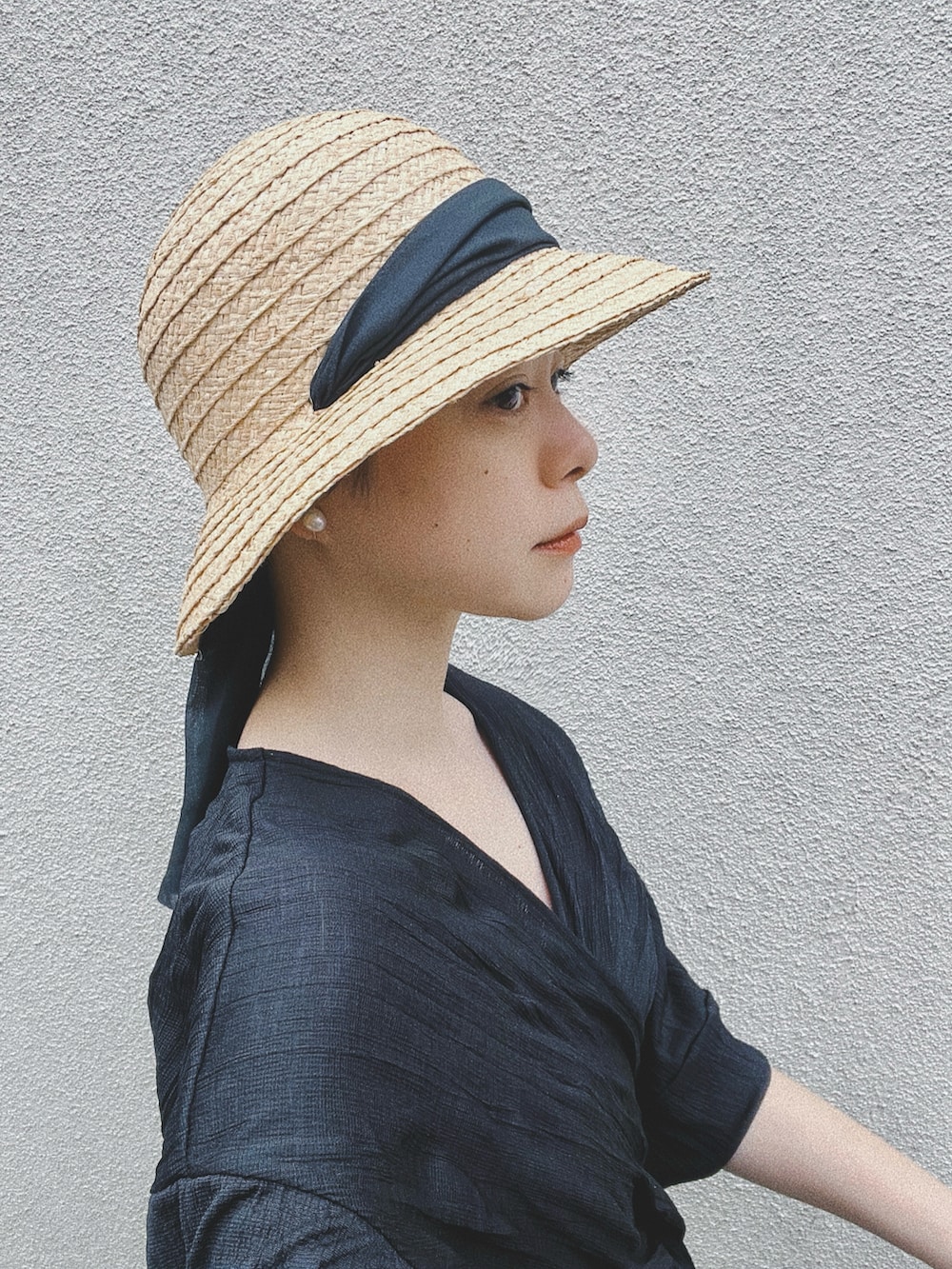 ブラック系のワンピース、ベージュ系の帽子、シルバー系のイヤーカフを着用したレディースの夏コーディネートの2枚目の写真