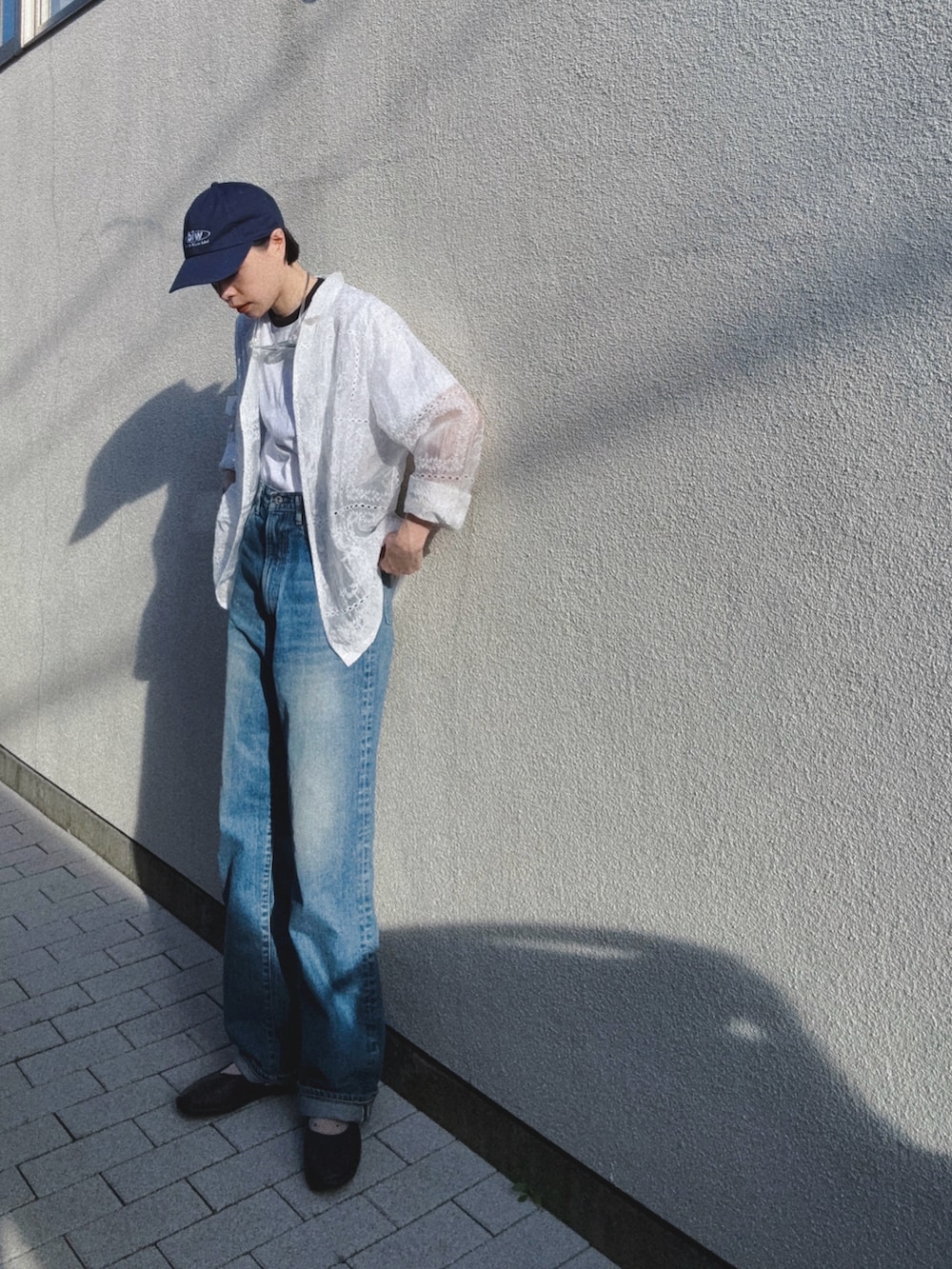 ブルー系のデニムパンツ、ホワイト系のTシャツ/カットソー、ホワイト系のテーラードジャケットを着用したレディースの春コーディネートの2枚目の写真