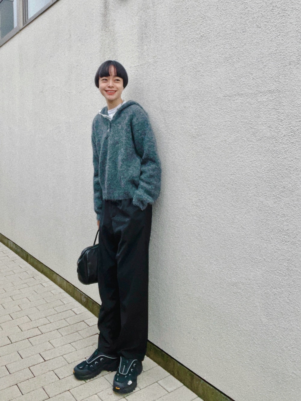 ブラック系のその他パンツ、グレー系のニット/セーター、ホワイト系のTシャツ/カットソーを着用したレディースの秋コーディネートの2枚目の写真