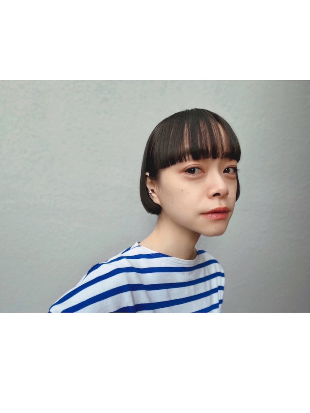 ブルー系のデニムパンツ、ブルー系のTシャツ/カットソー、シルバー系のイヤーカフを着用したレディースの冬コーディネートの2枚目の写真