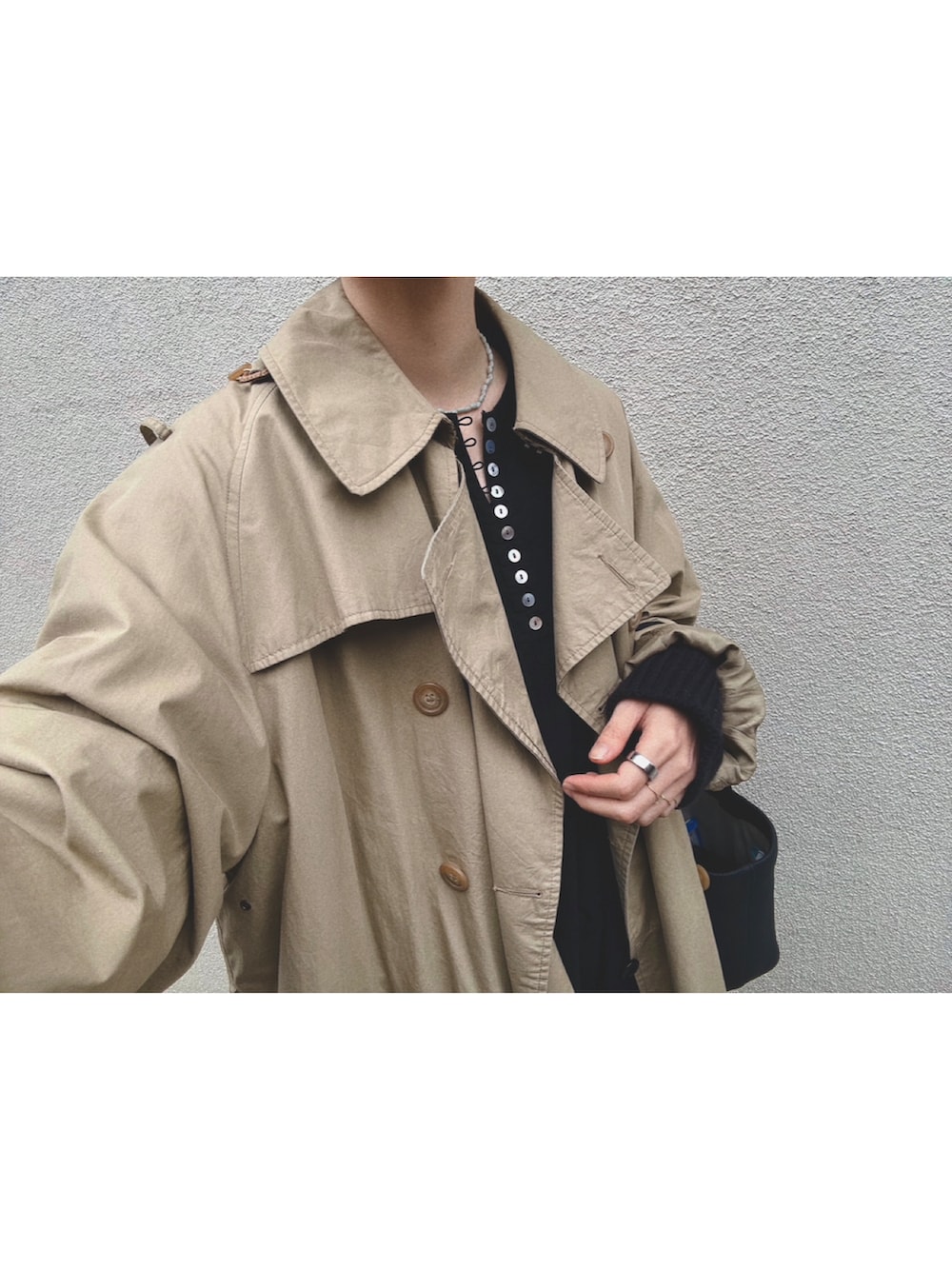 ベージュ系のトレンチコート、ブラック系のワンピース/ドレス、ブラック系のカーディガン/ボレロを着用したレディースの春コーディネートの3枚目の写真