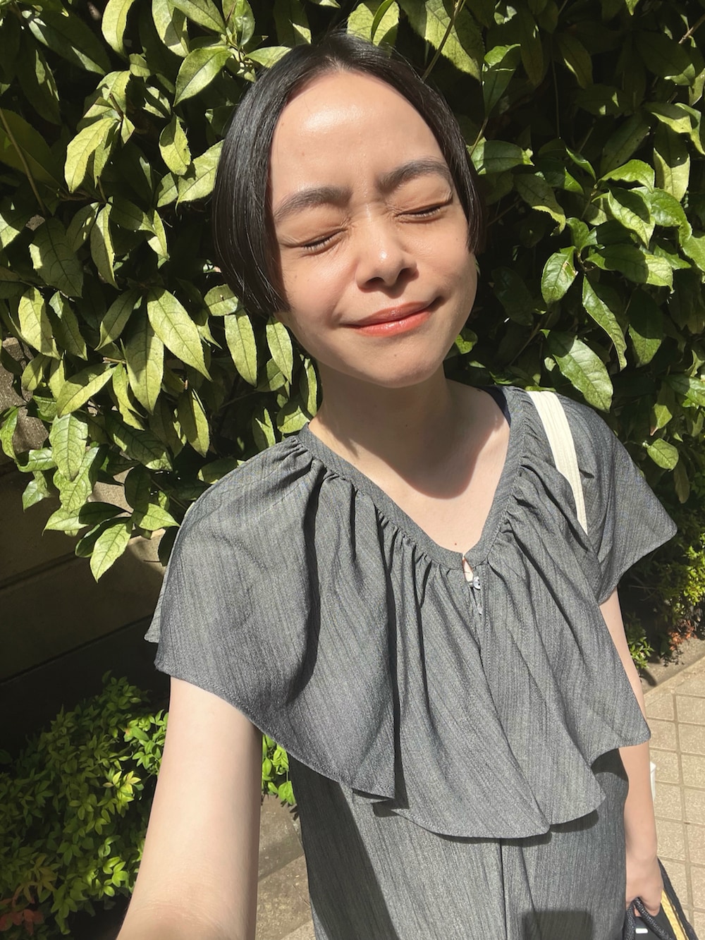 ブラック系のかごバッグ、グレー系のワンピース、ブラック系のサンダルを着用したレディースの夏コーディネートの2枚目の写真