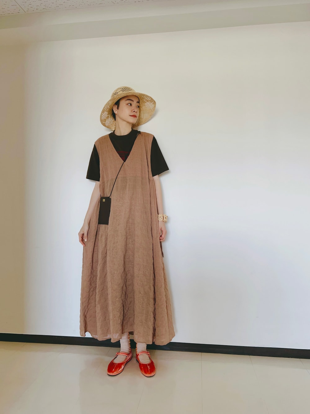 オレンジ系のワンピース、ブラウン系のTシャツ/カットソー、ピンク系のシューズを着用したレディースの春コーディネートの2枚目の写真