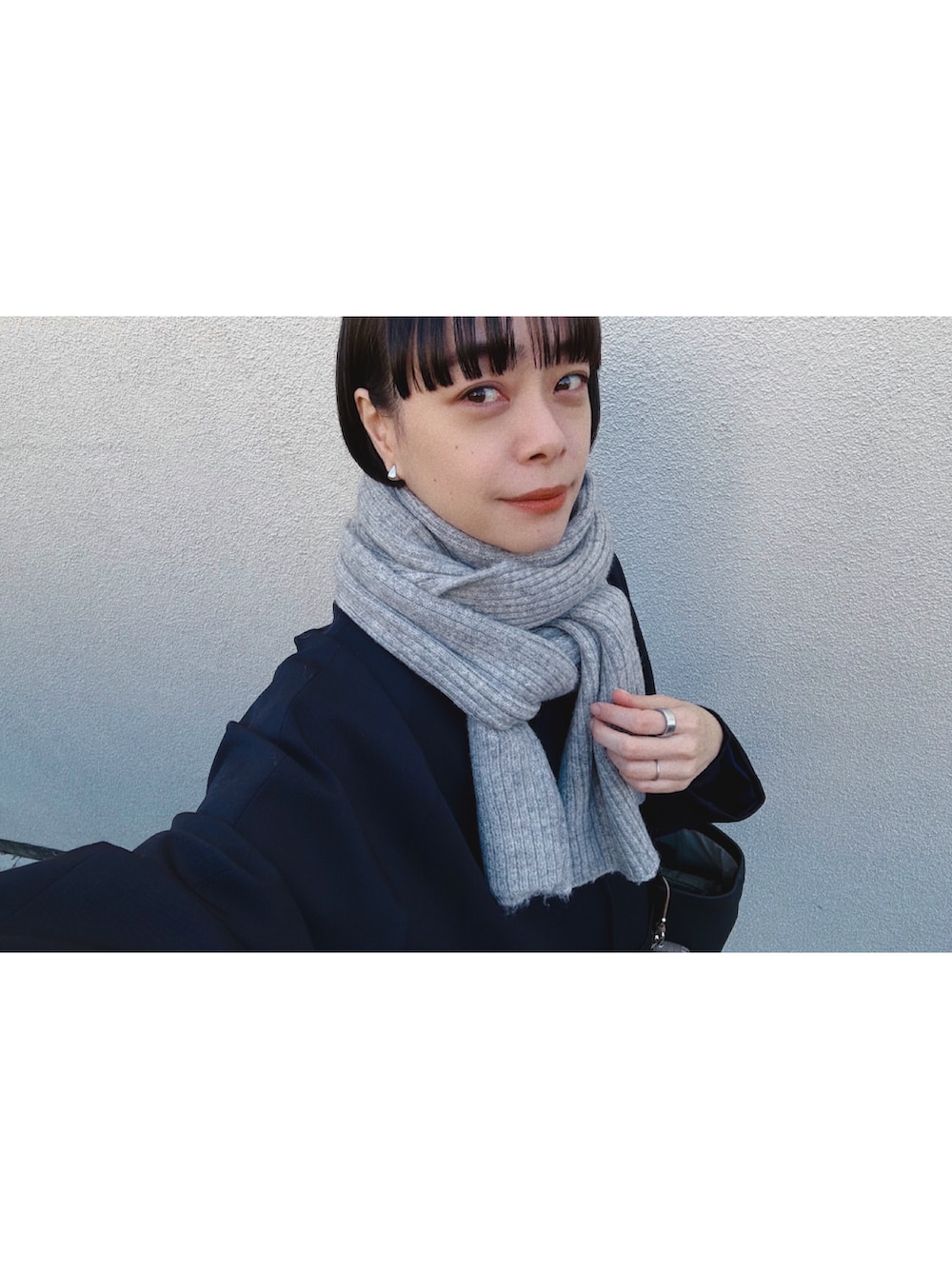 ブラック系のバッグ、ブルー系のニット/セーター、ブルー系のデニムパンツを着用したレディースの冬コーディネートの2枚目の写真