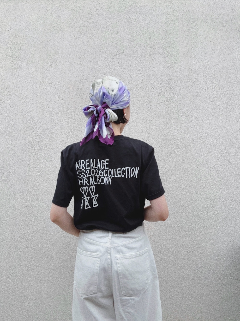 ホワイト系のデニムパンツ、ブラック系のTシャツ/カットソー、ブラック系のサンダルを着用したレディースの夏コーディネートの2枚目の写真