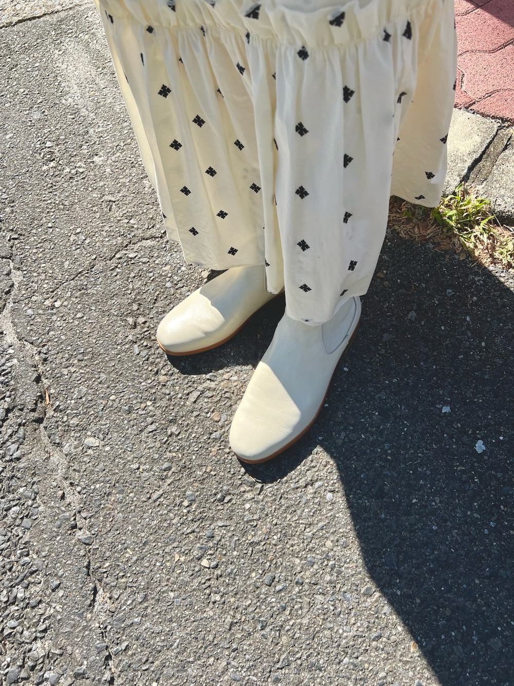 ホワイト系のワンピース、ベージュ系のバッグ、ホワイト系のブーツを着用したレディースの秋コーディネートの3枚目の写真